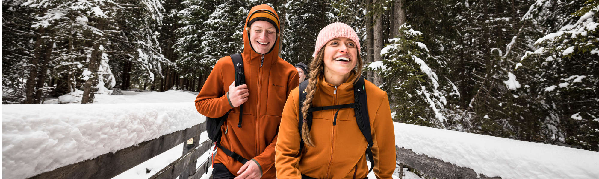 VAUDE Fabrikverkauf Obereisenbach Eine Frau und ein Mann laufen durch den schneebedeckten Wald