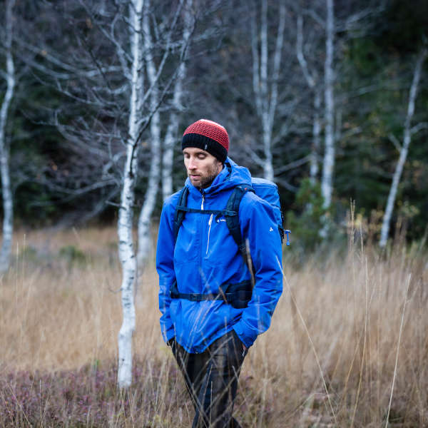 Ein Mann läuft, den Blick auf den Boden gerichtet durch eine Moorlandschaft