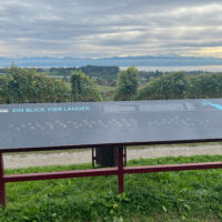 Aussichtspunkt in den Weinreben mit Infotafel und Blick auf den Bodensee