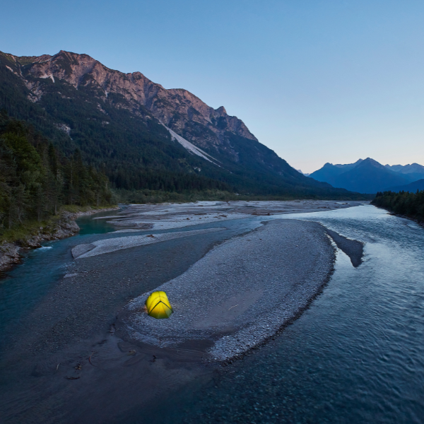Zelt auf einer Kiesbank im Fluss